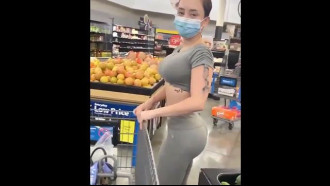 Gostosa comprando pepino no supermercado